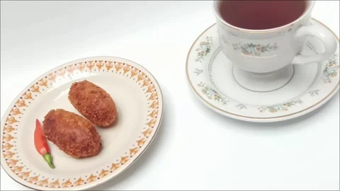 Fried croquettes on plate next to black coffee cup on white table Stock Footage 343510912