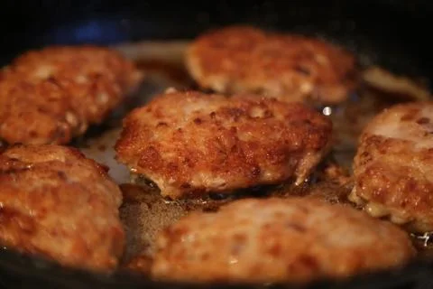 Fried cutlets on a frying pan Stock Photos