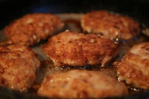 Fried cutlets on a frying pan Stock Photos