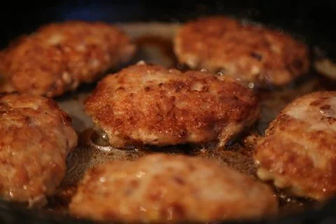 Fried cutlets on a frying pan Stock Photos