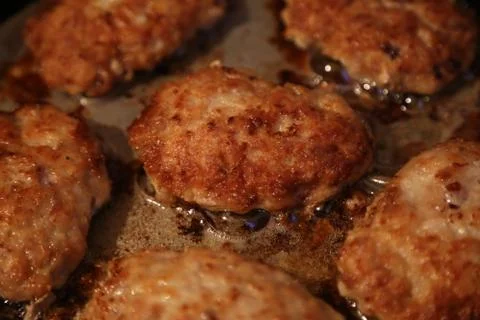 Fried cutlets on a frying pan Stock Photos