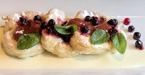 Fried donuts decorated with fruit dip and fruit. The donuts are filled with.. Stock Photos