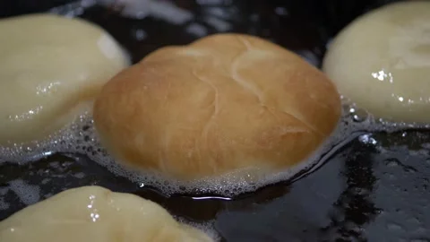 Fried donuts tossing for perfect consistency in deep oil Stock Footage 175165604