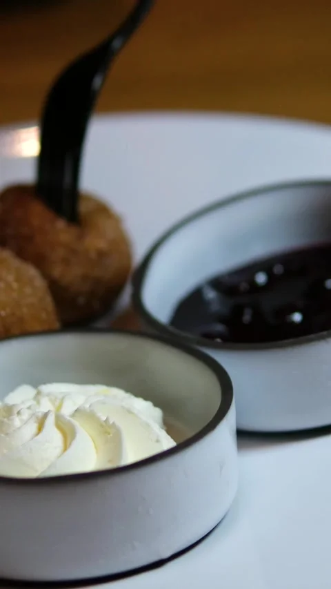 Fried dough balls in batter dipped in chocolate jam and sour cream with fork Stock Footage 318729815