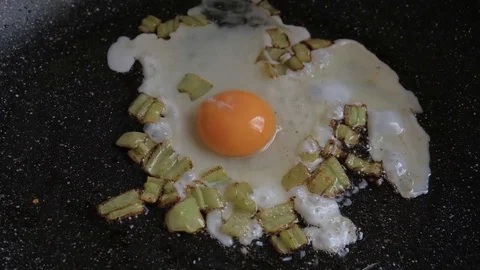 Fried egg and papers in a pan. Fried egg preparation on a frying pan. Stock Footage 106859247
