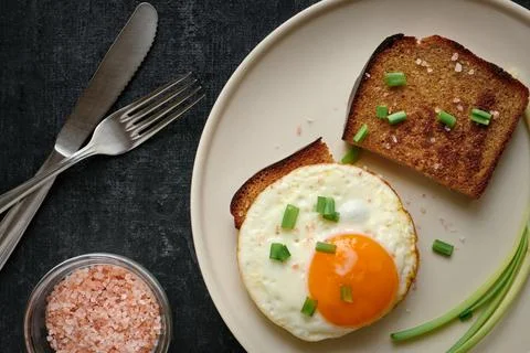 Fried egg and rye fried bread slices close up Stock Photos