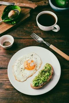 Fried egg and toast with mashed avocado Stock Photos