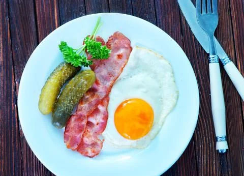 Fried egg with bacon on plate Stock Photos