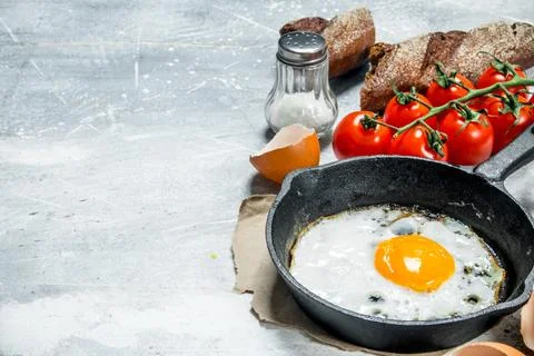 Fried egg with bread and tomatoes. Stock Photos