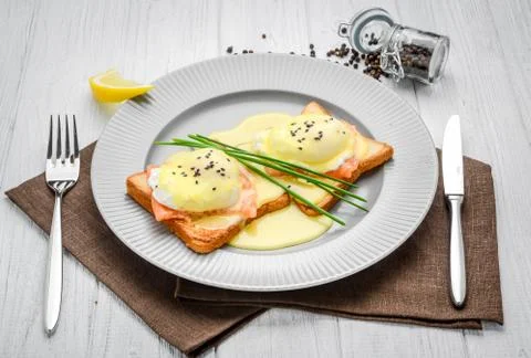 Fried egg on bread for breakfast on plate and rustic table, with salmon Stock Photos