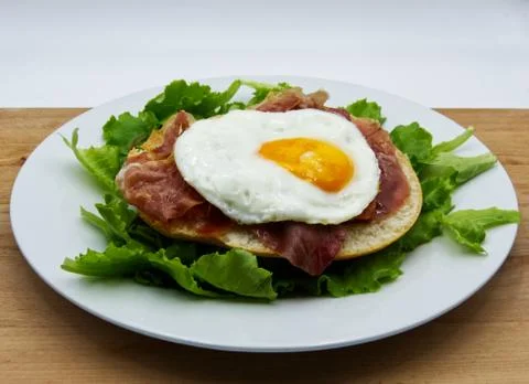 Fried egg with bread, ham, and salad Stock Photos