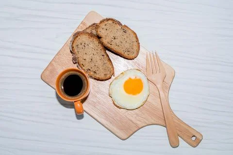 Fried egg bread slice in cutting board have espresso coffee on white background. Stock Photos