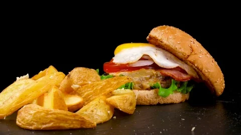 Fried Egg Burger with meat, bacon and Fried Potato wedges Stock Footage 84652378