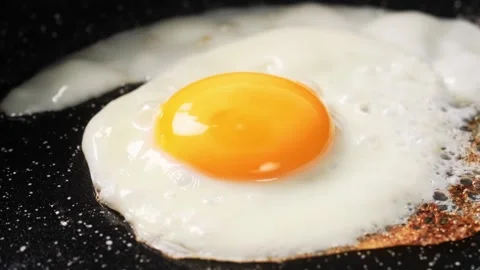 Fried egg. Chicken egg is fried in a frying pan close-up video 4k Stock Footage 242941913