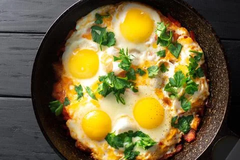 Fried egg. Close up view of the fried egg on a frying pan. Salted and spiced Photos