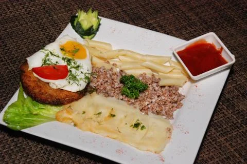 Fried egg with cutlet and garnish Stock Photos
