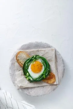 Fried egg with grean beans on toasted bread, copy space Stock Photos