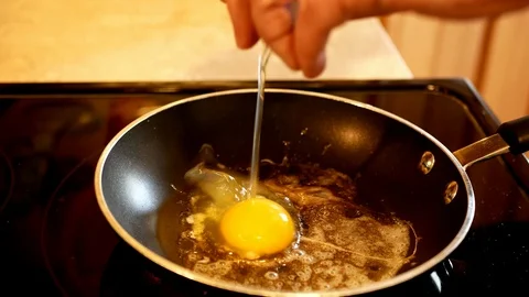 Fried egg in a hot pan. Broken egg dropped into the frying pan Stock Footage 103398827