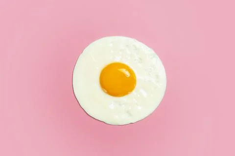 Fried egg is minimal. Fried egg isolate on a blank color light pink backgroun Stock Photos