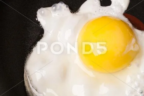 Fried egg with one yolk in pan Stock Photos