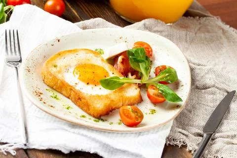 Fried egg in a piece of bread in a plate Stock Photos