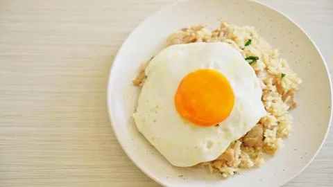 Fried egg on rice with vegetables on a white plate Stock Photos