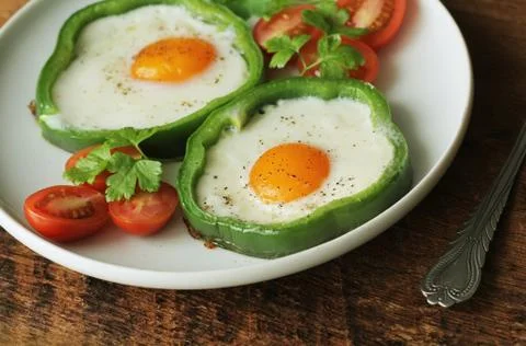 Fried egg in the ring of the bell peppers with herbs Stock Photos