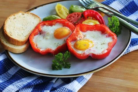 Fried egg in the ring of the bell peppers with herbs . Colorful healthy break Stock Photos