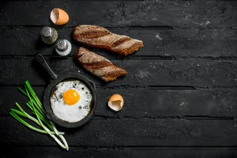 Fried egg with rye bread and spices. Stock Photos