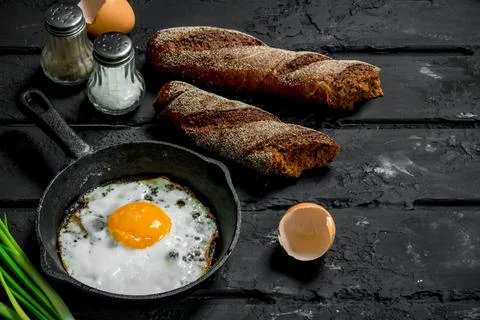 Fried egg with rye bread and spices. Stock Photos