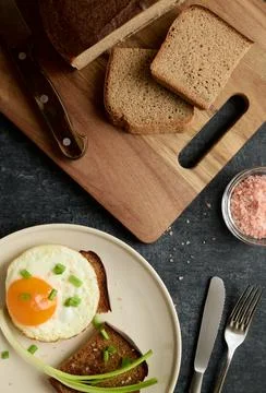 Fried egg, rye fried bread slices and pink salt, close up, top view Stock Photos
