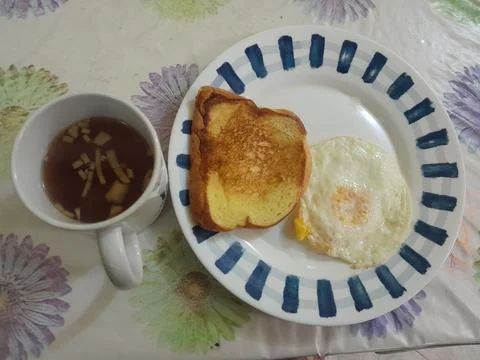 Fried egg with a slice of toasted bread, and ginger tea  snack Stock-Fotos
