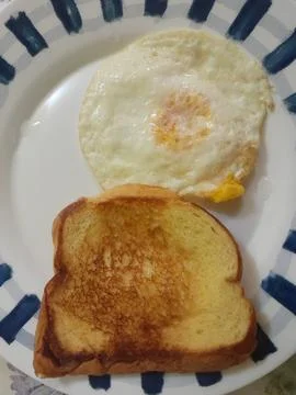 Fried egg with a slice of toasted bread snack on a ceramic plate Foto stock