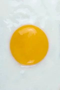 Fried egg sunny side up close up. Vertical top view. Stock Photos