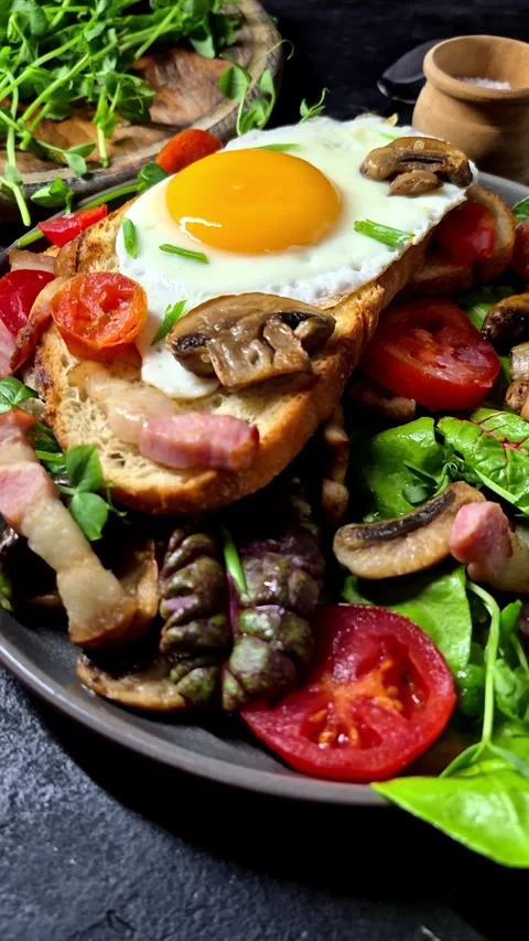 Fried egg on toast bread with bacon, tomatoes and lettuce Stock Footage 305064592