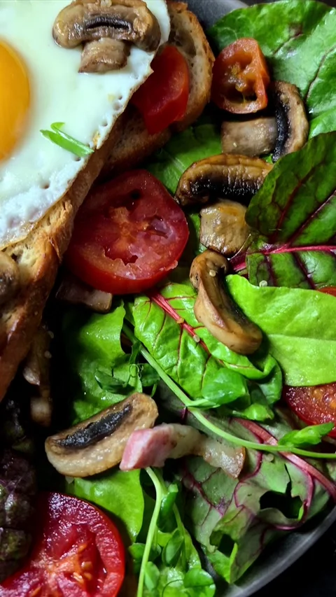 Fried egg on toast bread with bacon, tomatoes and lettuce Stock Footage 305064630