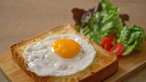 Fried egg on toast with side salad on wooden board Stock Photos
