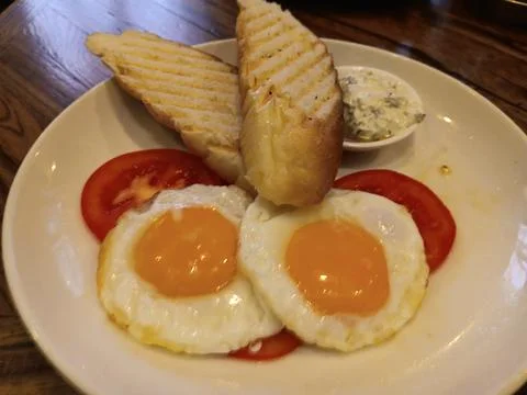 Fried egg, tomato, bread. Morning continental breakfast in Almaty, Kazakhstan. Stock Photos