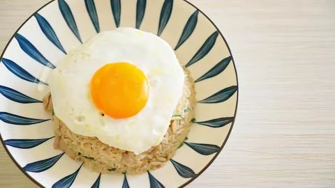 Fried egg with yolk on a patterned plate on a white surface Stock Photos