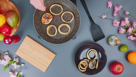 Fried eggplant rings being prepared on kitchen table overhead Stock Footage 342936216