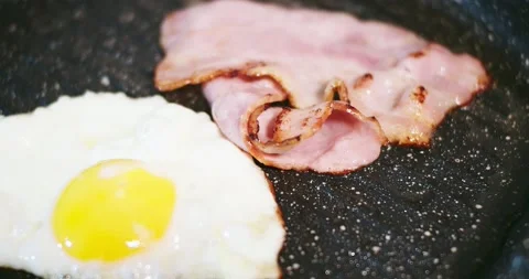 Fried Eggs And Bacon In A Pan Stock Footage 144012632