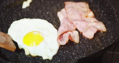 Fried Eggs And Bacon In A Pan Stock Footage 144012643