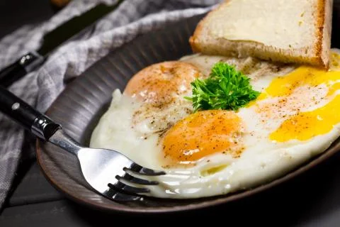 Fried eggs and brea. Stock Photos