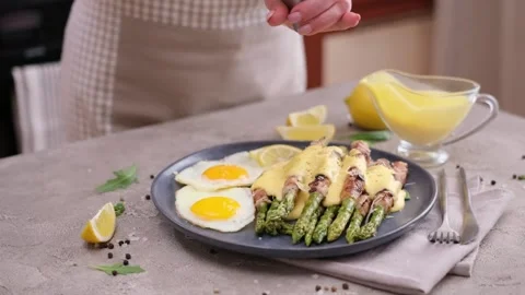 Fried eggs and freshly cooked asparagus wrapped with bacon on a plate Vídeos de archivo 218222365