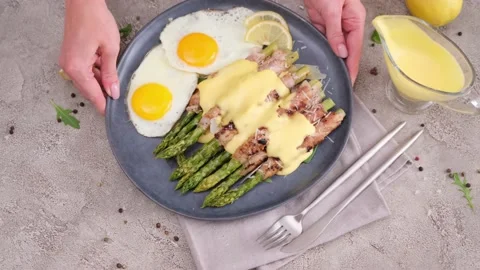 Fried eggs and freshly cooked asparagus wrapped with bacon on a plate Vídeos de archivo 218222604