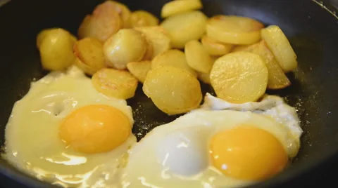 Fried eggs and fried potatoes Video stock 45358670