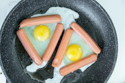 Fried eggs and fried sausages for breakfast or dinner Stock Photos