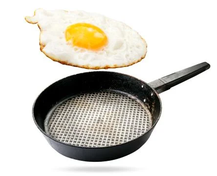 Fried eggs and a frying pan float in the air on a white, isolated. Fotos Stock