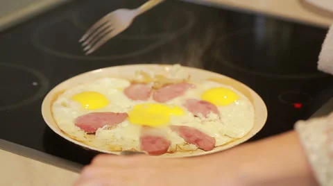 Fried eggs and ham in a pan for breakfast. Cooking Stock Footage