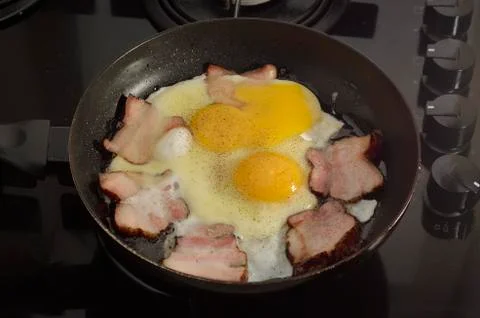 Fried eggs and ham Stock Photos